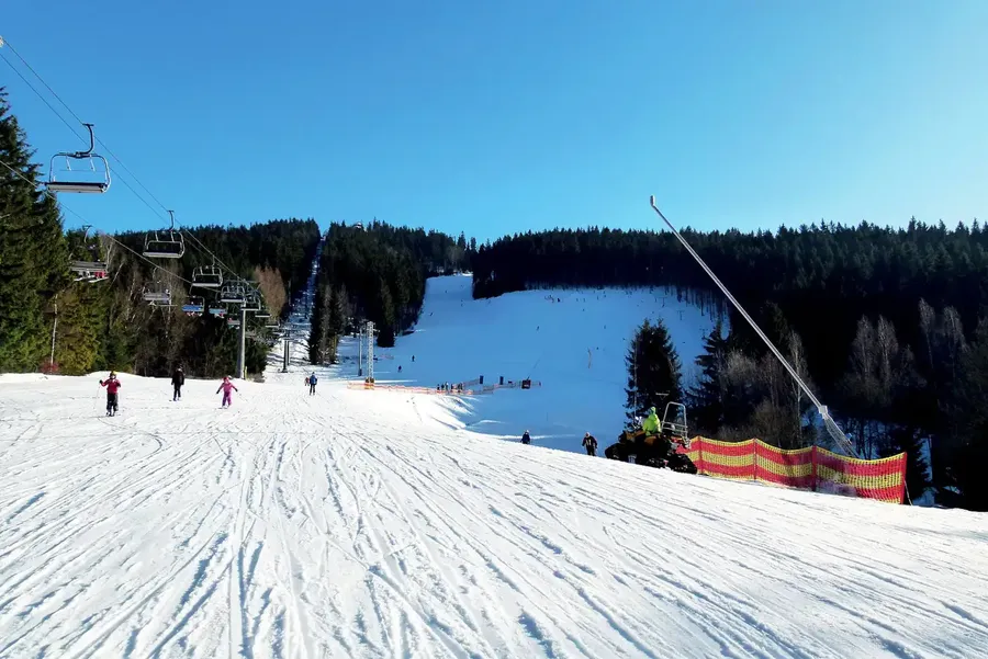 Zasněžená sjezdovka a lanovka ve skiareálu Tanvaldský Špičák